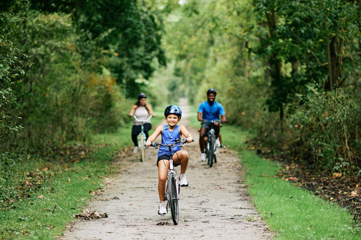 Family biking along the NCR Trail during a fall getaway in Baltimore County