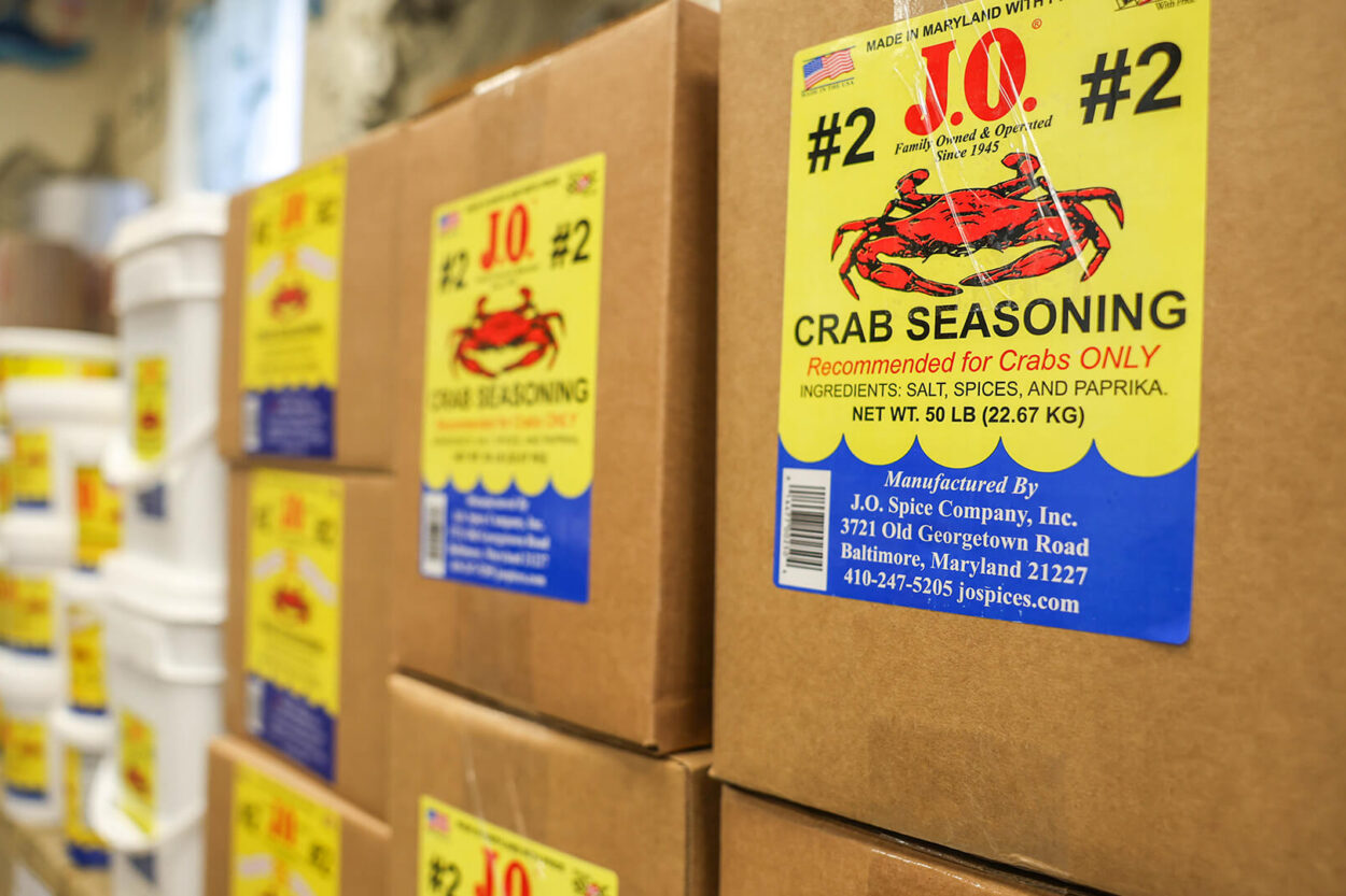 Story of J.O. Spice Company Inc. featuring boxes of J.O. Crab Seasoning No. 2 stacked in the warehouse