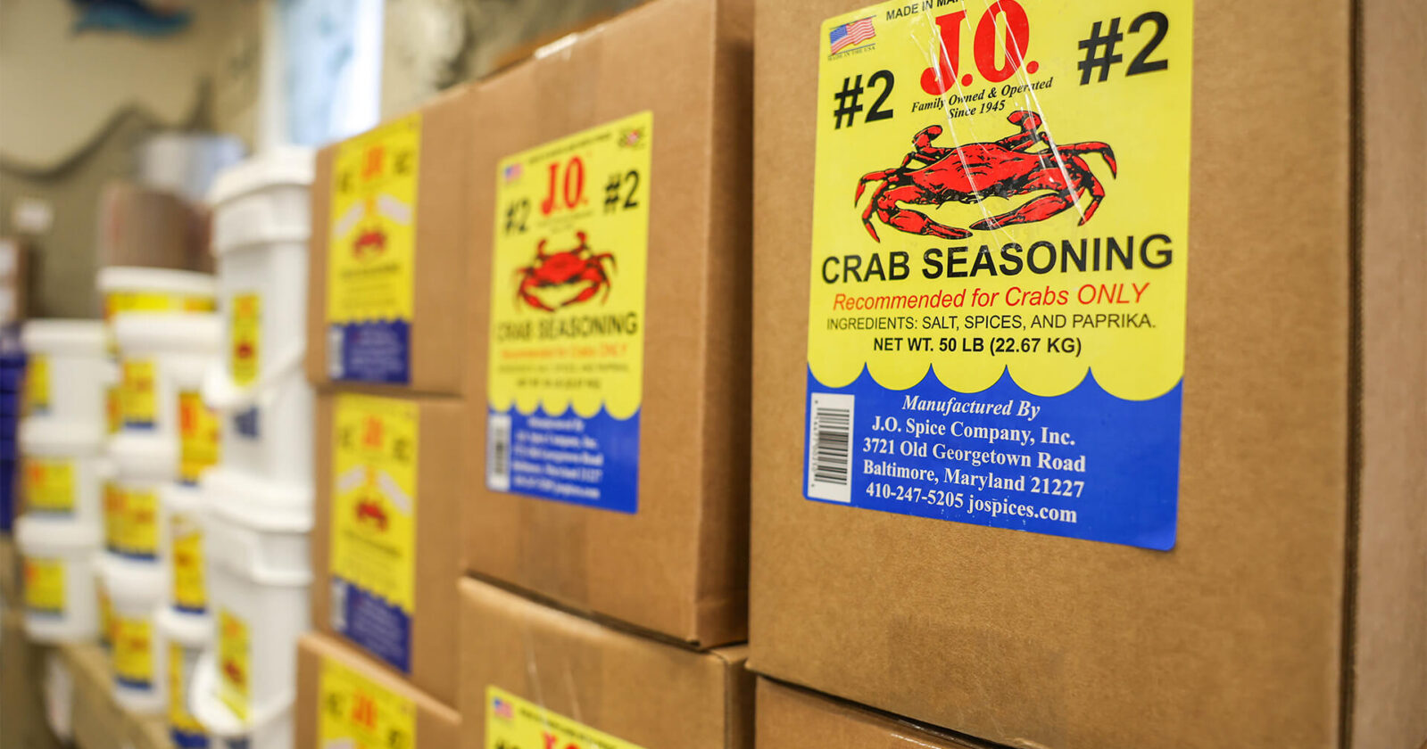 Story of J.O. Spice Company Inc. featuring boxes of J.O. Crab Seasoning No. 2 stacked in the warehouse